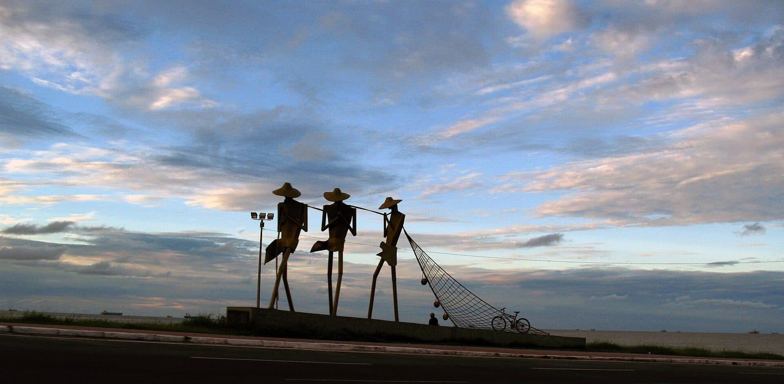 Escultura de três pescadores puxando a rede, na orla de São Luís